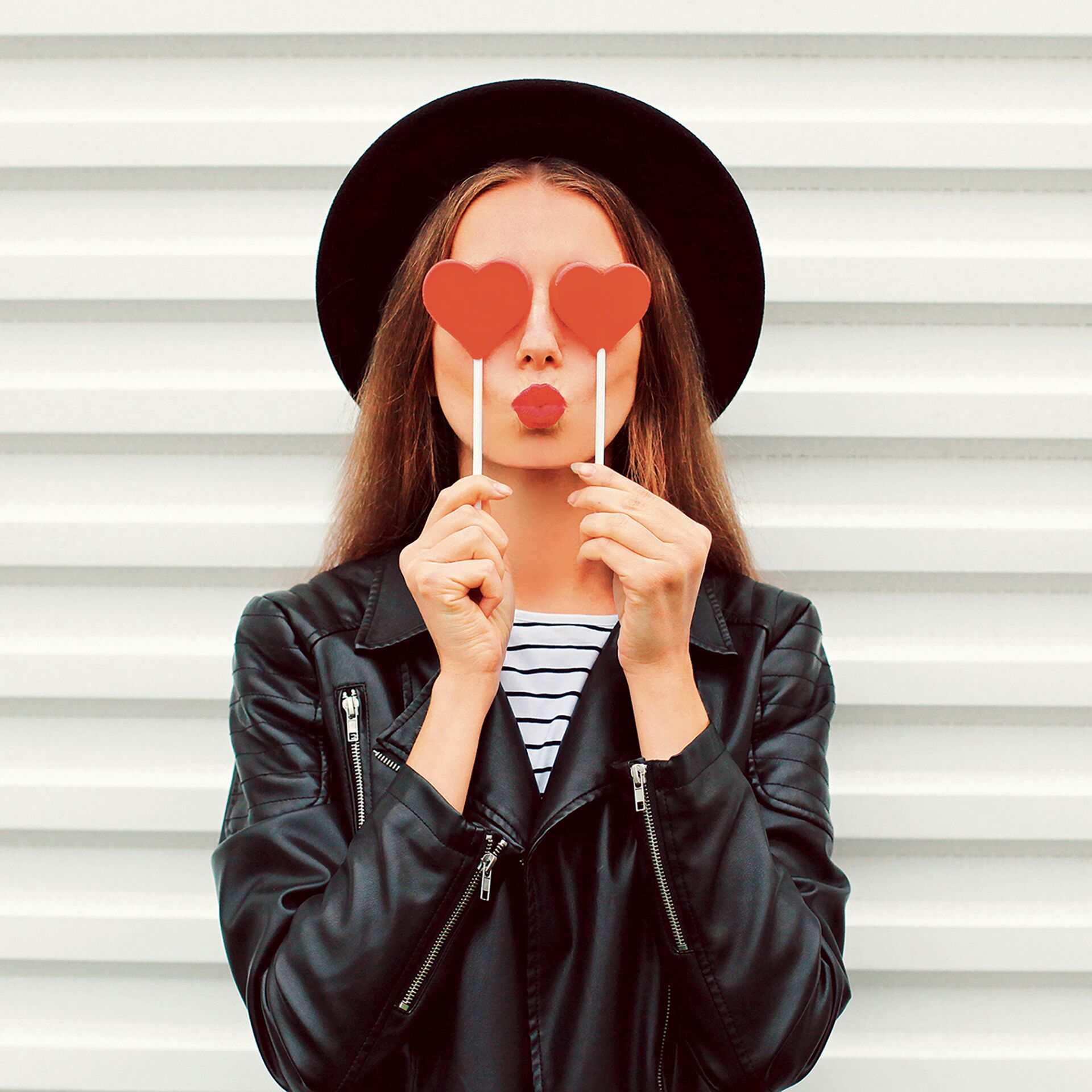Femme avec des sucettes-coeur devant les yeux